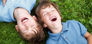 brothers lying in grass laughing